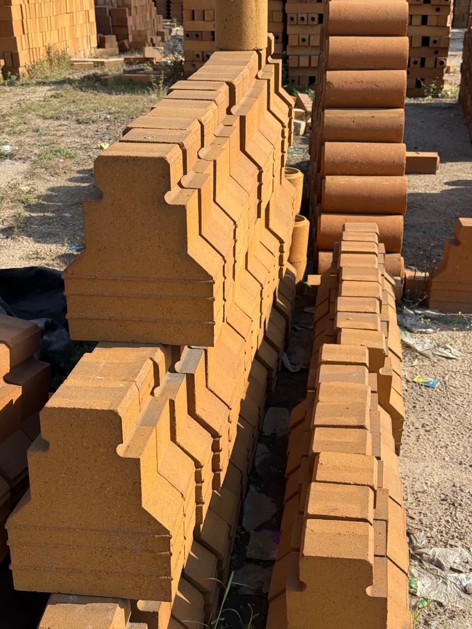 Shaped refractory bricks stacked in a brick yard
