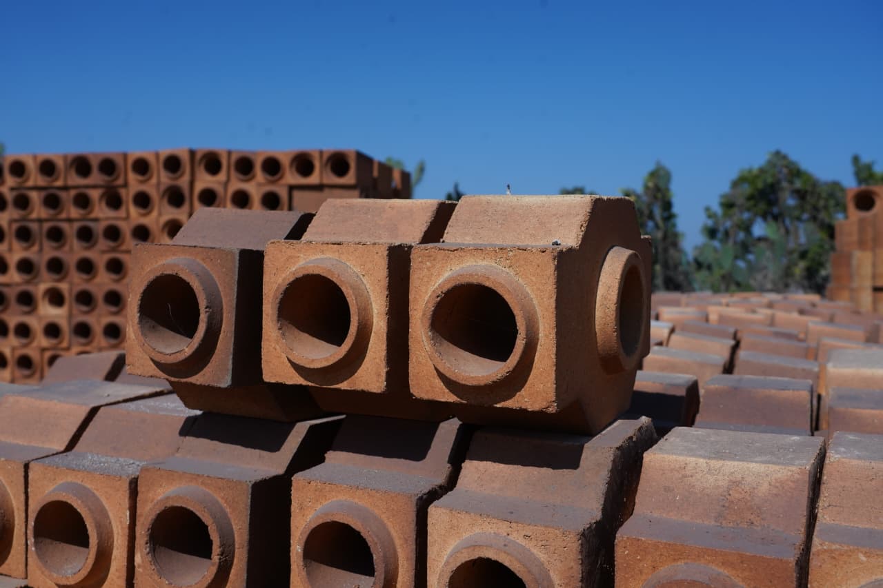 Refractory bricks with round holes stacked outdoors
