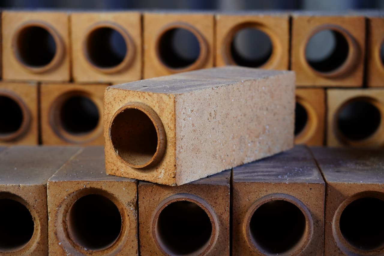 Refractory brick with a round through-hole